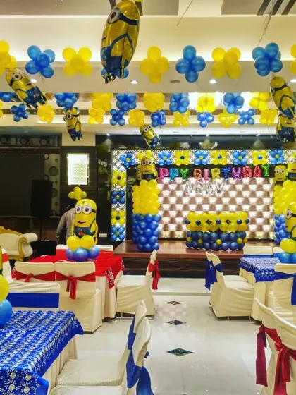 This is a full hall decoration for a Minions theme party. I did the stage backdrop, table centerpieces, and ceiling balloons, all matching the blue and yellow theme.