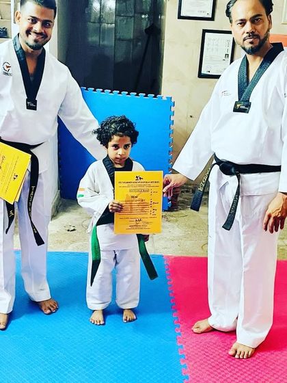 Even our smallest students achieve great things. This little one is proudly holding his new green belt certificate.