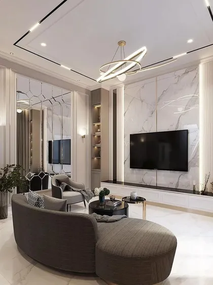 I designed this living room to be a statement of modern luxury. The centerpiece is a full-wall media unit with a marble-finish backdrop and integrated accent lighting. The space is tied together with a contemporary chandelier, custom wall paneling, and a curved sofa that enhances the room's sophisticated flow.