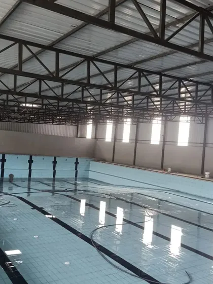 A clear view of our six-lane, 25-meter indoor short course pool. The covered structure and high windows provide a bright, climate-controlled space for year-round swimming.