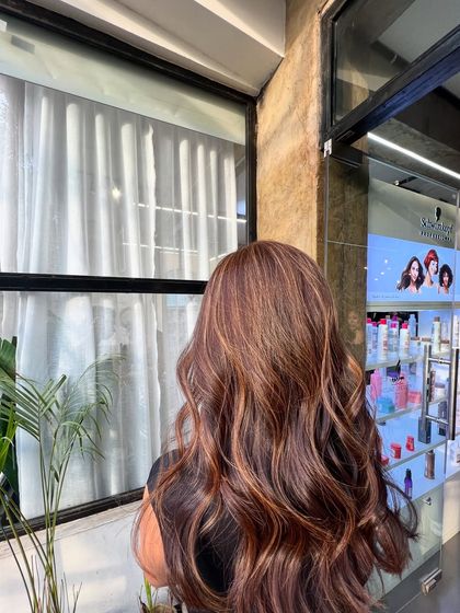 This lived-in hair color features warm, coppery highlights on a dark base, creating a rich and vibrant look perfect for any season.