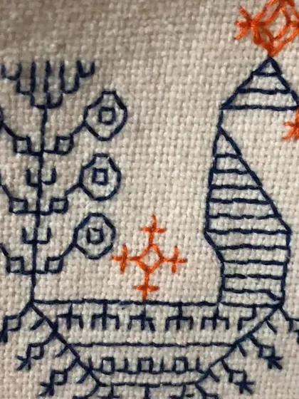 A close-up of a stylized peacock and tree motif done in Kasuti. This demonstrates how the simple running stitch can be used to create figurative and symbolic patterns.