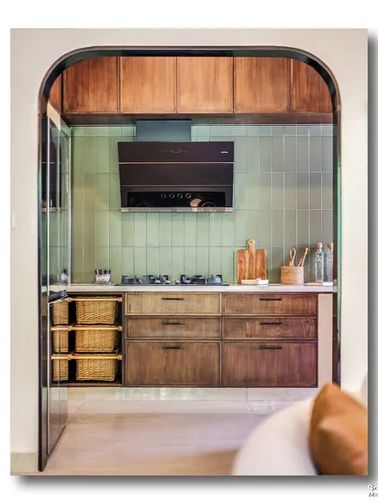 An arched view into a modern kitchen, where warm wood cabinets contrast beautifully with mint green tiles. The clever use of an archway frames the kitchen like a picture, making it a standout feature of the home.