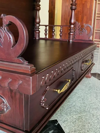 This angle shows the functional design of the mandir, with carved drawers for storing puja essentials. The classic brass handles complement the dark wood finish perfectly.