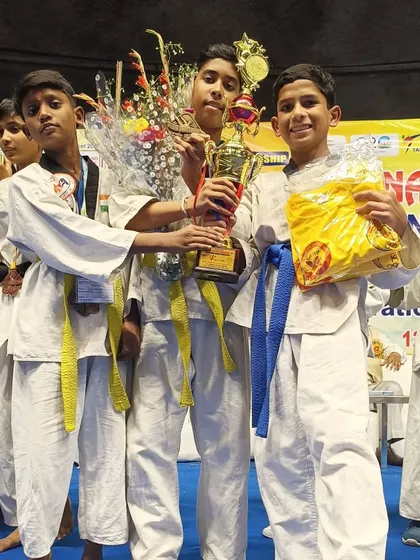 Our young champions holding their trophies and prizes after a successful national championship.