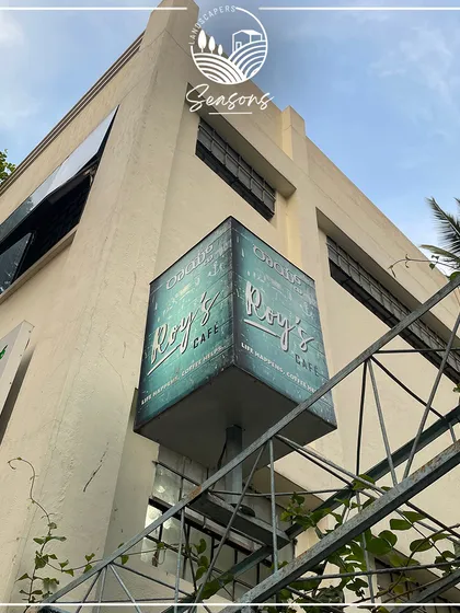 The sign for Roy's Cafe, one of our ongoing projects. This image marks the beginning of a transformation, where we will bring nature's beauty to life in their outdoor space.