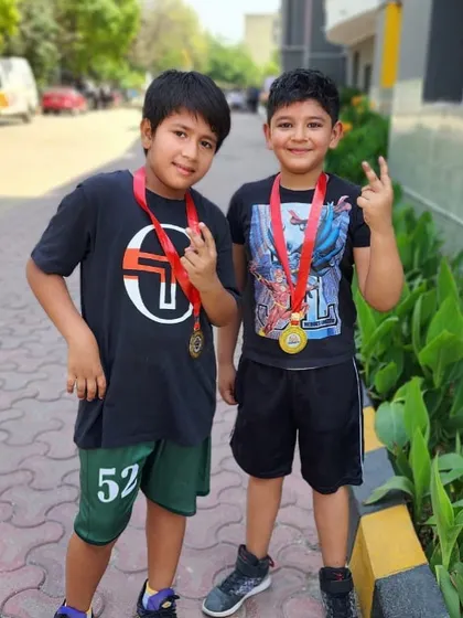 Two of our young players proudly showing off their medals after a successful competition. Their smiles say it all.