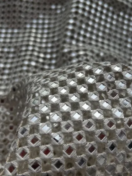 A beautiful beige version of our popular cutwork fabric. The neutral tone allows the shimmering details to truly shine.