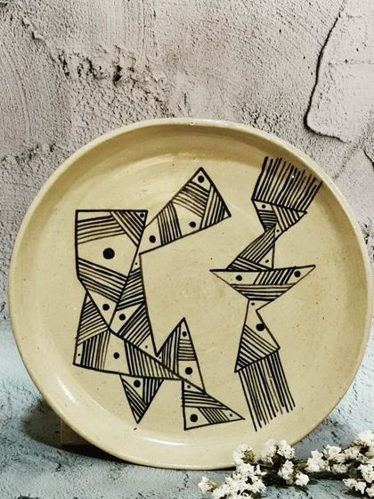 A beautifully handcrafted ceramic plate with a unique abstract geometric design. This piece is perfect for everyday use, adding a touch of modern art to your table.