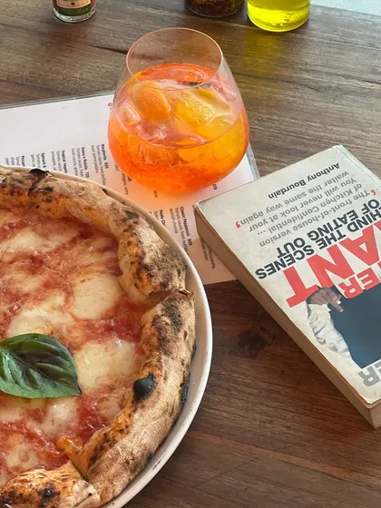 My idea of a perfect afternoon involves a good book, a refreshing Aperol Spritz, and a classic Margherita pizza. It's about slowing down and savouring the simple things.