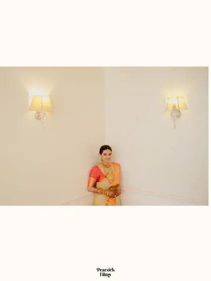 A minimalist bridal portrait. The bride stands in a simple, elegant pose against a plain white wall, her beauty shining through.