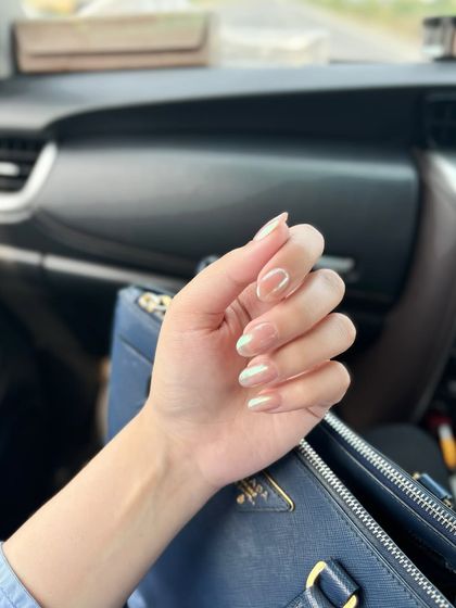 The pearly chrome nails seen in a car, showing how they catch the natural light.