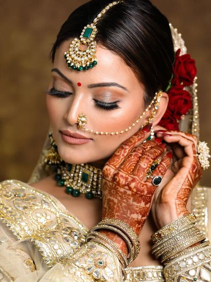 A detailed shot of this elegant golden bridal look. The focus is on the neutral shimmery golden eyes, which catch the light beautifully, paired with a timeless nude lip.
