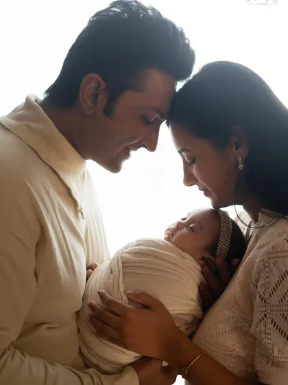 A classic backlit portrait, creating a halo of light around the new family and emphasizing their emotional connection.