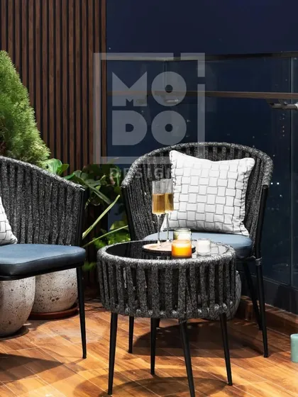 A closer look at the intimate seating arrangement on this balcony. The woven chairs and matching table create a perfect setting for two to enjoy the city view.