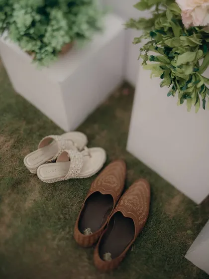 The bride's and groom's shoes, resting side-by-side. A simple, symbolic shot of two paths about to merge into one.