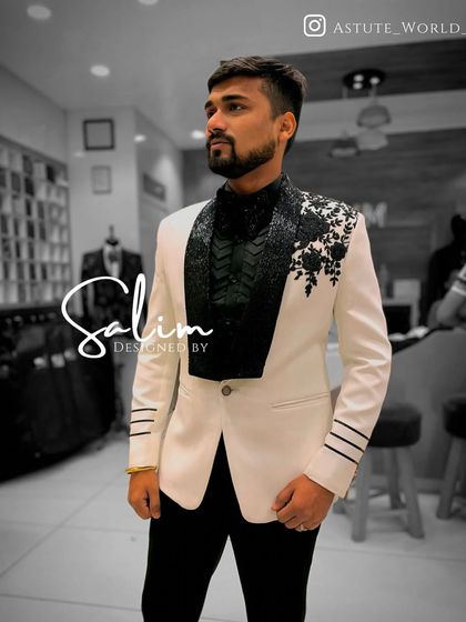A client in a white tuxedo jacket with a contrasting black embellished lapel and floral appliqué. This black and white design is timeless yet completely modern.