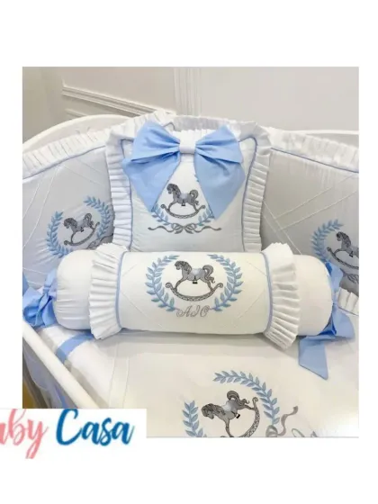 A classic and charming bedding set for a little boy. This design features a rocking horse theme embroidered in blue and grey, with a mix of bolster and bow-shaped pillows for a playful touch.