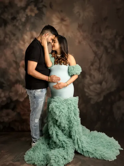 The connection between partners is a beautiful part of the maternity story. This intimate couple's portrait, set against a soft floral backdrop, captures a quiet moment of love and anticipation.