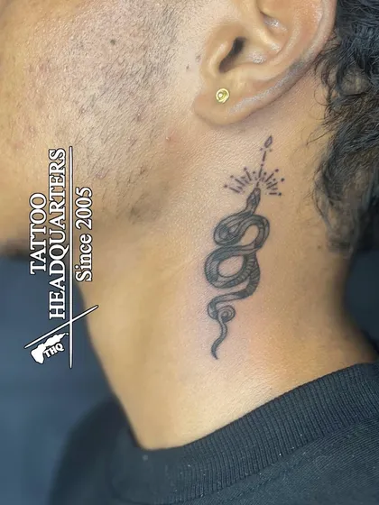 A classic gold stud in the earlobe. This client also got a fine-line snake tattoo on their neck, showcasing how we can help you combine different forms of body art.