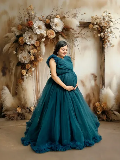 For those who love a touch of fairytale magic, I offer styled sessions with beautiful maternity gowns like this teal one. The floral backdrop and soft lighting create a dreamy, romantic portrait for the mom-to-be.
