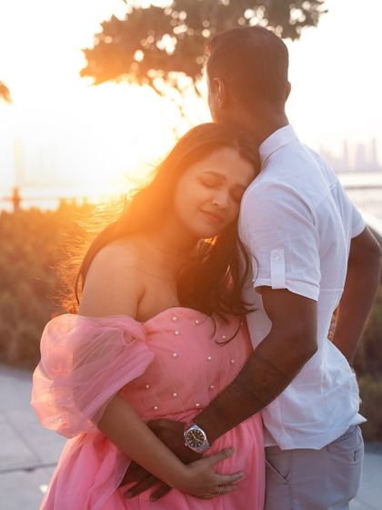A tender embrace, with eyes closed in a moment of pure bliss. The setting sun casts a beautiful golden light, making this outdoor couple's portrait incredibly warm and intimate.