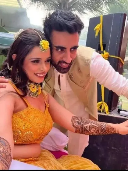 A happy couple taking a selfie to capture the memory of their mehandi ceremony.