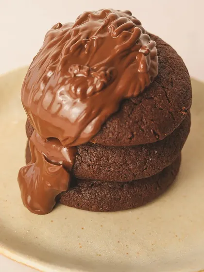 Sweet, gooey, and irresistible. A stack of our double chocolate cookies getting a generous topping of Nutella.