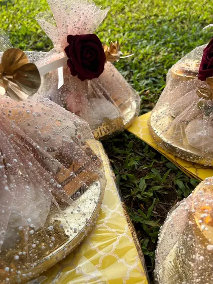 These beautifully wrapped gift platters are perfect for any festive occasion. The glittering net and floral details add a touch of magic.