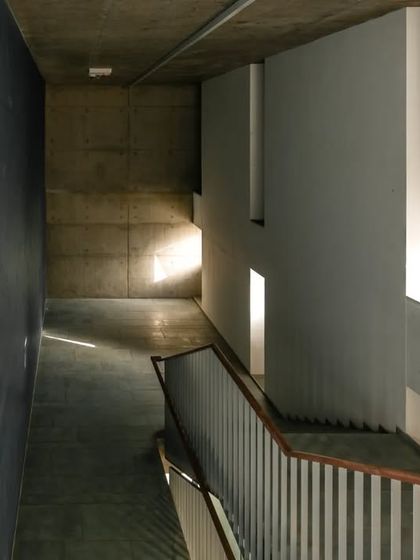 The play of light and shadow in a stairwell at the JSW School of Public Policy. The simple, robust materials of concrete and steel are elevated by the careful consideration of how natural light enters and moves through the space.