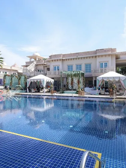 A wide shot of the beautiful poolside venue, showing the luxurious setup with draped canopies and comfortable lounge areas.