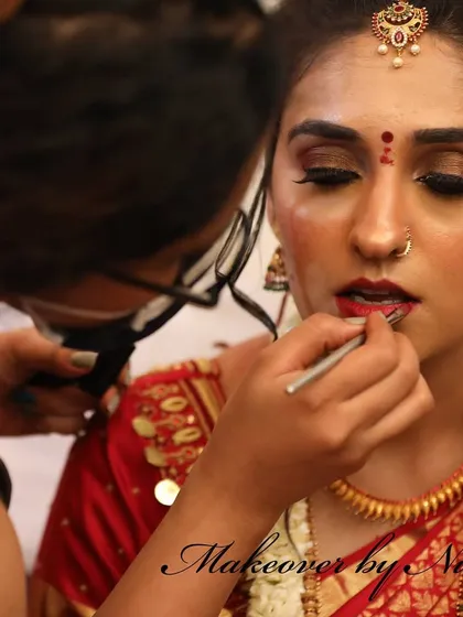 The art of makeup is in the details. Here, I am carefully applying eyeshadow and lipstick for Pooja, ensuring every element is perfect for her muhurtham.