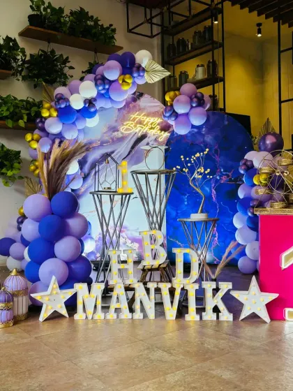 This first birthday setup has a very chic and modern feel, using a purple marble-effect backdrop. The combination of purple, gold, and white creates a unique and stylish look.