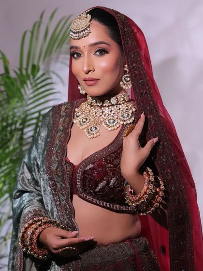 A rich, velvety look in deep maroon and green. The heavy polki necklace and maang tikka make this a perfect outfit for a winter wedding reception.