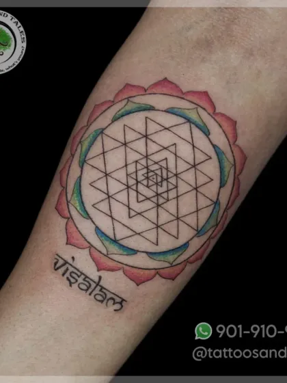 A Shri Yantra tattoo, a sacred geometric symbol, done with fine lines and soft color shading in the surrounding lotus petals. This piece was done by our artist, Maxy.