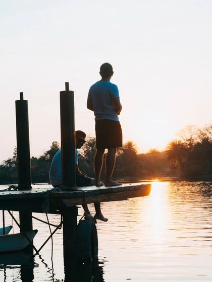 Two people enjoying the sunset from the dock, a perfect end to an adventurous day.