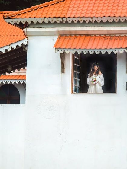 A simple, elegant bridal portrait, with the bride framed in the window of a classic Goan house.
