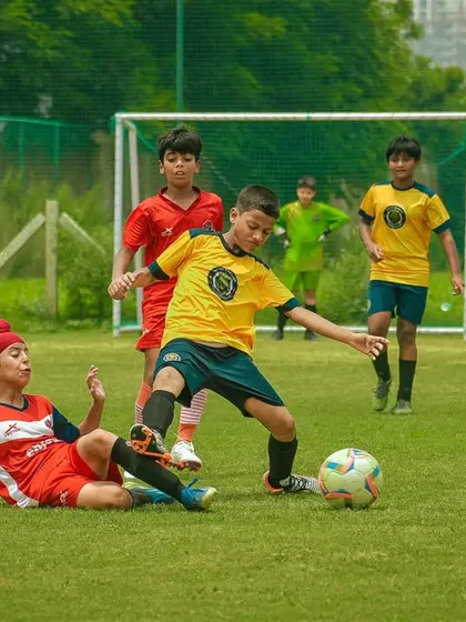 A player on the ground attempts to tackle an opponent, showing relentless effort.