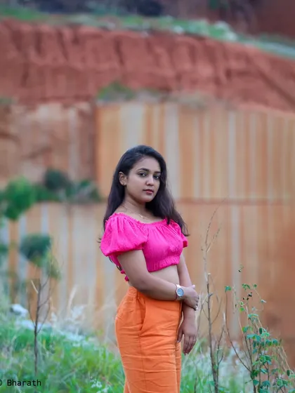 A wider shot that shows the contrast between the bright outfit and the muted tones of the quarry-like background.