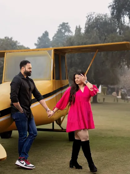 A couple holds hands while walking away from our yellow airplane prop, creating a sense of adventure and journey. This is a popular shot for pre-wedding and save-the-date photography.