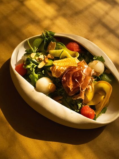 The beautiful, sculptural bowl holding our prosciutto and melon salad, where even the tableware is a piece of art.