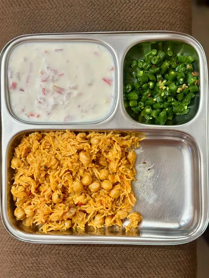 A vegetarian meal of channa rice, raita, and sautéed green beans. This one-pot rice dish is a quick and easy way to get a balanced meal.