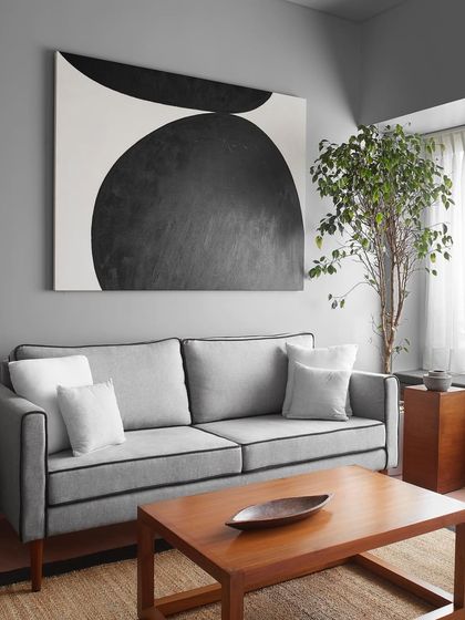 The living room features a sofa with elegant black piping, a detail I specified to give the piece a sharp, tailored look. It sits next to a custom wooden coffee table, creating a modern yet warm centerpiece.