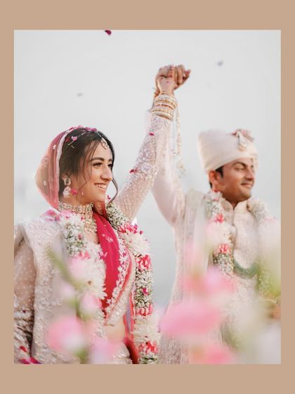 A moment of pure celebration after the wedding ceremony. The shower of petals and the couple's raised hands create a dynamic and joyful photograph.