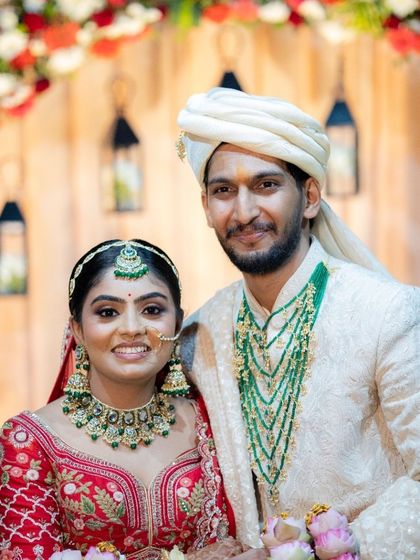 A classic portrait of the happy couple, posing for the camera in front of their beautifully decorated wedding backdrop.