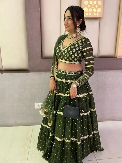 A smiling shot of my client in her custom green lehenga. The V-neck blouse and full sleeves with matching embroidery create a balanced and elegant silhouette.