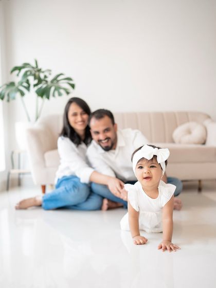 A family portrait with the baby crawling towards the camera.