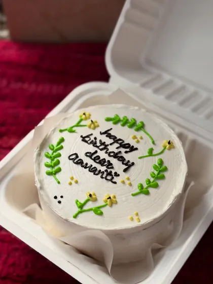 A simple and pretty bento cake with a hand-piped wreath of leaves and flowers. This minimalist style is very popular.