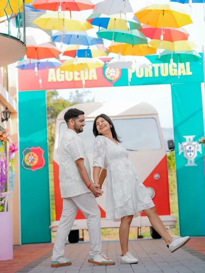 A fun, dynamic shot of the couple walking through a colorful, Portugal-themed alleyway. This set offers a unique and vibrant background for a pre-wedding shoot that feels like a European holiday.