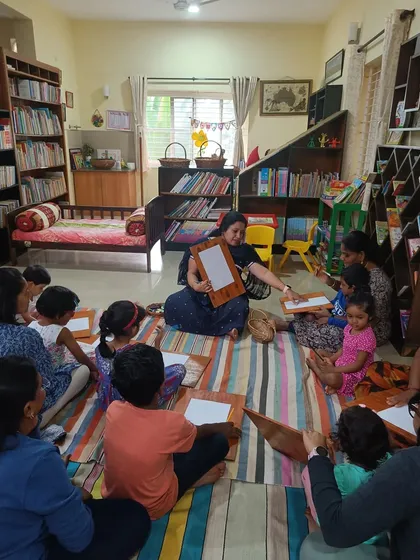A wide shot of the drawing session, with everyone finding their own space to create on the colorful mat.